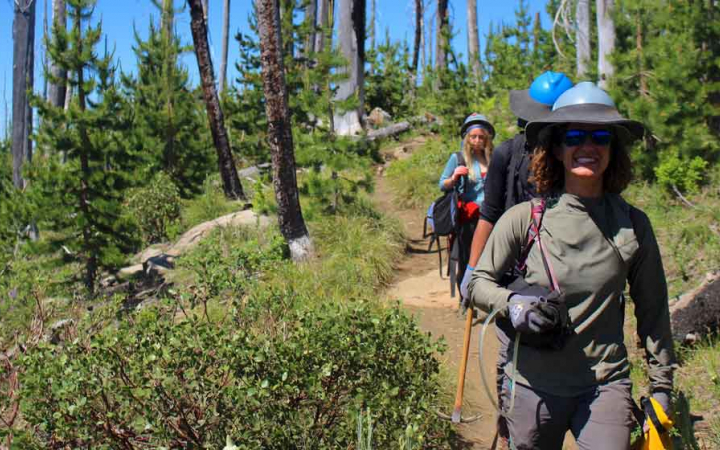 a group of people walk along a trail during a service project 
